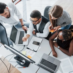 grupo-de-pessoas-multinacionais-ocupadas-trabalhando-no-escritorio-olhando-o-computador-e-o-celular